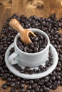 Aerial view of white coffee cup with roasted coffee beans and spoon, on wooden table, selective focus, Royalty Free Stock Photo