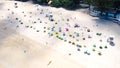 Aerial view of the white sand beach full of umbrellas and people resting during their holidays