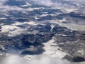 Aerial view of white snowscape and cloudscape covering landscape below in winter, wallpaper, in white, Scandinavia, Royalty Free Stock Photo