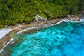 Aerial view of wild secluded lonely beach with rough granite rocks, white sand, palm trees in a jungle and turquoise Royalty Free Stock Photo