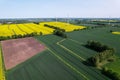 Aerial view Wind turbine on grassy yellow farm canola field against cloudy blue sky in rural area. Offshore windmill Royalty Free Stock Photo