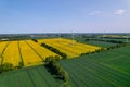 Aerial view Wind turbine on grassy yellow farm canola field against cloudy blue sky in rural area. Offshore windmill Royalty Free Stock Photo