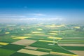 Aerial view of wind turbine. Rapeseed blooming. Windmills and yellow fields from above. Agricultural fields on a summer day. Royalty Free Stock Photo