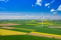 Aerial view of wind turbine. Rapeseed blooming. Windmills and yellow fields from above. Agricultural fields on a summer day. Royalty Free Stock Photo