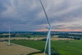 Aerial view of wind turbine with wheat and maize fields in summer. Aerial view of Eolian generator with agriculture fields in the