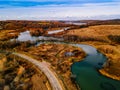 Aerial view of winding river and road in golden colored fall forest Royalty Free Stock Photo