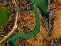 Aerial view of winding river and road in golden colored fall forest Royalty Free Stock Photo