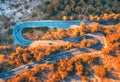 Aerial view of winding road in autumn forest at sunset Royalty Free Stock Photo