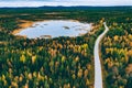 Aerial view of winding road and golden colored autumn or fall forest Royalty Free Stock Photo