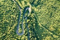 Aerial view of winding road in high mountain pass trough dense green pine woods Royalty Free Stock Photo