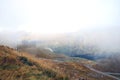 Aerial view of a winding road in the mountains on a foggy autumn morning. Alps. Danger when driving in fog Royalty Free Stock Photo