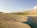 Aerial view of a winding road that runs along the Croatian coasts, dirt road, island of Pag near Rucica beach in Metajna. Croatia