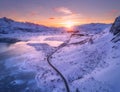 Aerial view of winding road, snow covered mountains at sunset Royalty Free Stock Photo