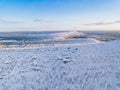 Aerial view of winter forest with frosty trees, rural road and village in Finland Royalty Free Stock Photo