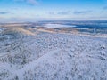 Aerial view of winter forest with frosty trees, rural road and village in Finland Royalty Free Stock Photo