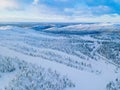 Aerial view of winter forest with frosty trees, rural road and village in Finland Royalty Free Stock Photo