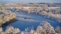 Aerial view of a winter landscape with a sunset casting a glow over a snow-covered field