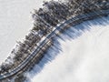 Aerial view of a winter road between two frozen lake. Winter landscape countryside. Aerial photography of snowy forest and frozen Royalty Free Stock Photo