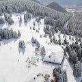 Aerial view of winter ski resort on tourists skiing on slopes of mountain forest valley, Pamporovo, Bulgaria