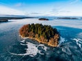 Aerial view of the winter snow forest and frozen lake from above captured with a drone in Finland. Royalty Free Stock Photo