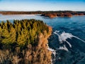 Aerial view of the winter snow forest and frozen lake from above captured with a drone in Finland. Royalty Free Stock Photo