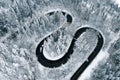 Aerial view of a winter winding highway in the middle of the forest