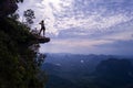 Aerial view of woman on the edge of the rock on the mountain view point