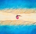 Aerial view of woman on sandy beach with waves on the both sides Royalty Free Stock Photo