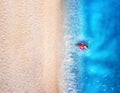 Aerial view of a woman with swim ring in blue sea, sandy beach Royalty Free Stock Photo