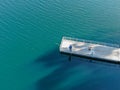 Aerial view of wood pier with fishers and their fishing rods trying to catch fish