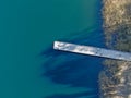 Aerial view of wood pier with fishers and their fishing rods trying to catch fish