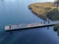 Aerial view of wood pier with fishers and their fishing rods trying to catch fish