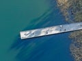 Aerial view of wood pier with fishers and their fishing rods trying to catch fish