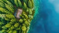 Aerial view of wooden cabin or cottage in green pine forest by the blue lake Royalty Free Stock Photo