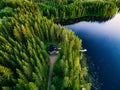 Aerial view of wooden cottage in green forest by the blue lake in rural summer Finland