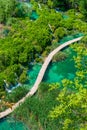 Aerial view of wooden footpath trail at Plitvice lakes, Croatia. Tourist path above blue lagoon near the waterfalls. Empty bridge Royalty Free Stock Photo