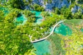 Aerial view of wooden footpath trail at Plitvice lakes, Croatia. Tourist path above blue lagoon near the waterfalls. Empty bridge Royalty Free Stock Photo