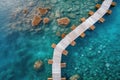 Aerial view of a wooden over water bridge in the turquoise ocean on tropical island.