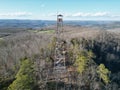 an aerial view of the woods, mountains and a tower