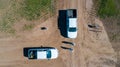 Aerial view of 4x4 pickup truck driving through wheat crops field with silos bags on the road.