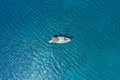 An aerial view of the yacht on the azure sea. Transparent clear water in the Mediterranean Sea. Summer vacations and travels on a Royalty Free Stock Photo