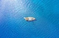 An aerial view of the yacht on the blue sea. Transparent clear water in the sea. Summer vacations and travels on a sailing yacht.