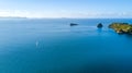 Aerial view on a yacht racing along tiny island ocean on sunny day. Coromandel Peninsula, New Zealand Royalty Free Stock Photo