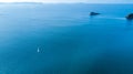 Aerial view on a yacht racing along tiny island ocean on sunny day. Coromandel Peninsula, New Zealand Royalty Free Stock Photo