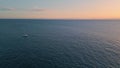 Aerial view yacht sailing to sunset horizon. Evening sundown reflecting at ocean