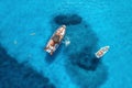 Aerial view of yachts and swimming people in blue sea at sunset