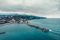 Aerial view of Yalta embankment from drone, old Lighthouse on pier, sea coast landscape and city buildings on mountains, Crimea Royalty Free Stock Photo