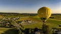 Aerial View on a Yellow Hot Air Balloon Floating Over a Countryside Community