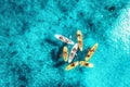 Aerial view of yellow kayaks in blue sea at sunset in summer