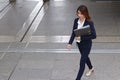 Aerial view of young attractive Asian business woman holding document folder and walking on flooring in the city against copy spac Royalty Free Stock Photo